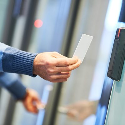 Employee using a commercial access control card reader for secure entry in a Perth business